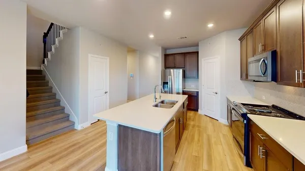 a kitchen with a sink and wooden floor