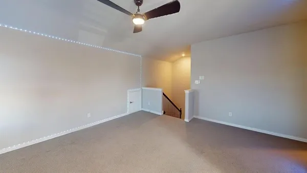 en empty room with ceiling fan and window