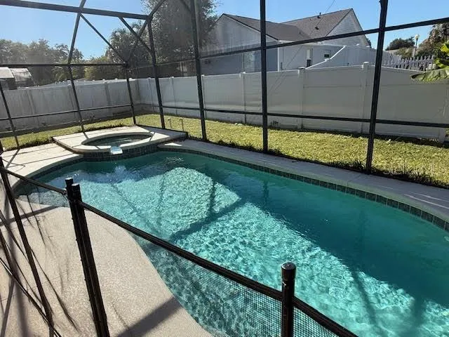 a view of a swimming pool with a bench and wooden fence