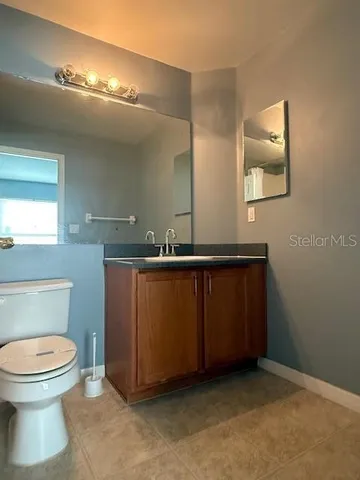 a bathroom with a toilet a sink and mirror