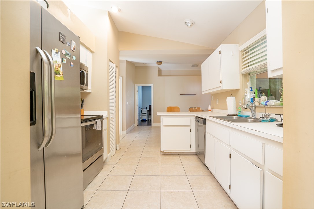 18404 Fuchsia Road Fort Myers, FL 33967 - Photo 4 of 25 a kitchen with a refrigerator sink and cabinets