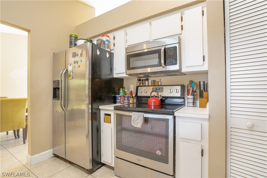 18404 Fuchsia Road Fort Myers, FL 33967 - Photo 5 of 25 a kitchen with stainless steel appliances granite countertop a refrigerator a stove and a sink with wooden floor