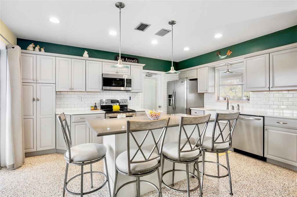 223 Roberts Road Nokomis, FL 34275 - Photo 12 of 27 a kitchen with stainless steel appliances kitchen island granite countertop a stove a sink and a refrigerator