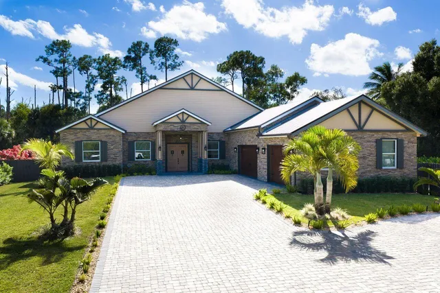 a front view of a house with a yard and a garden