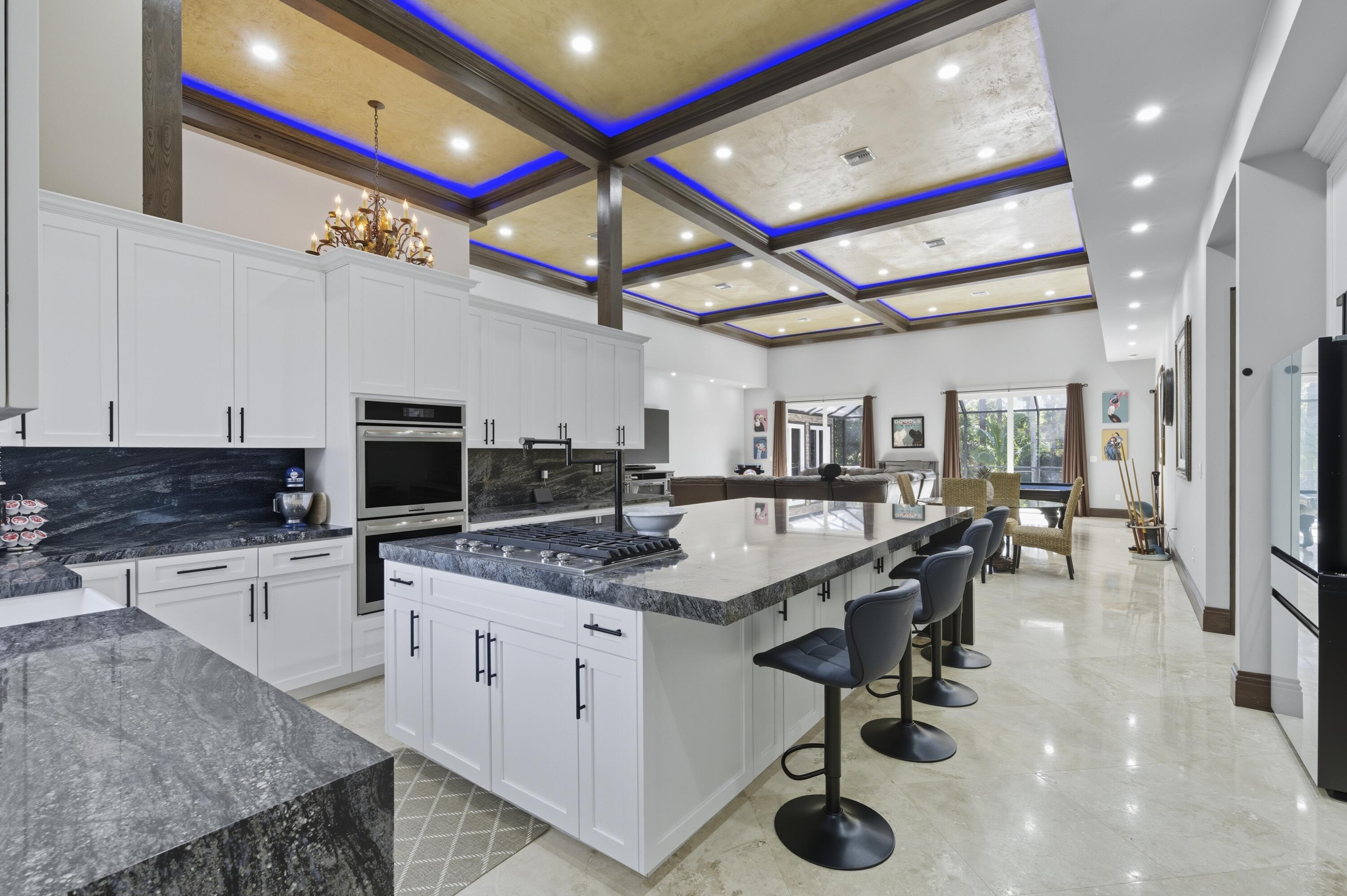 8350 Whispering Oak Way West Palm Beach, FL 33411 - Photo 12 of 51 a kitchen with stainless steel appliances granite countertop a sink a stove and a wooden floors