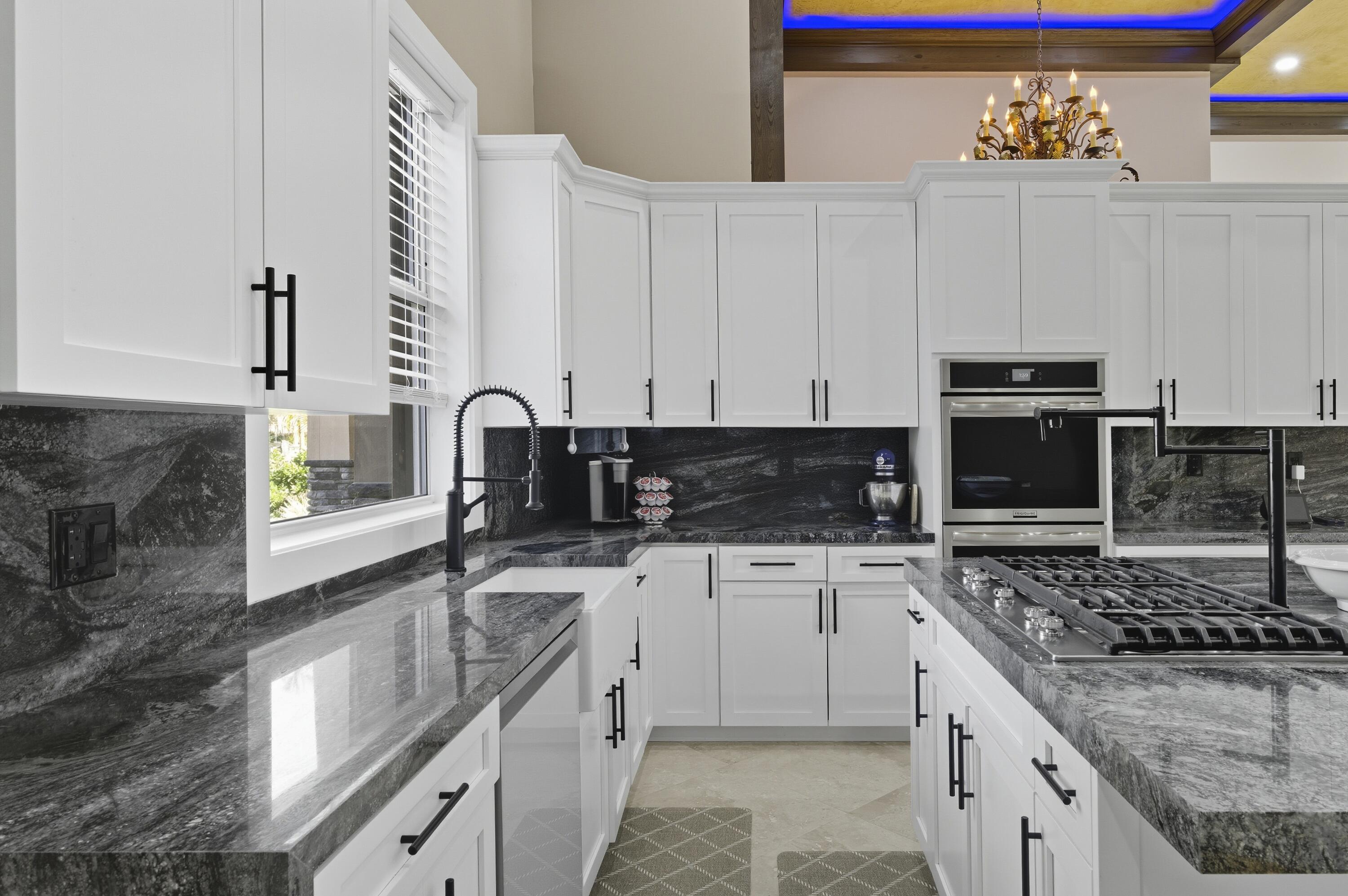 8350 Whispering Oak Way West Palm Beach, FL 33411 - Photo 13 of 51 a kitchen with granite countertop a stove sink and cabinets