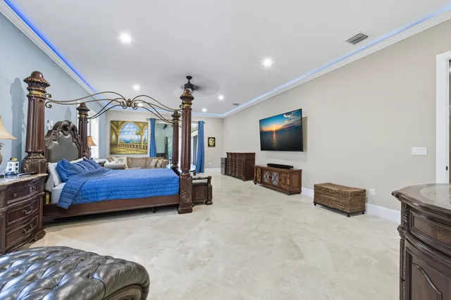 a bedroom with a bed a dresser and a chandelier