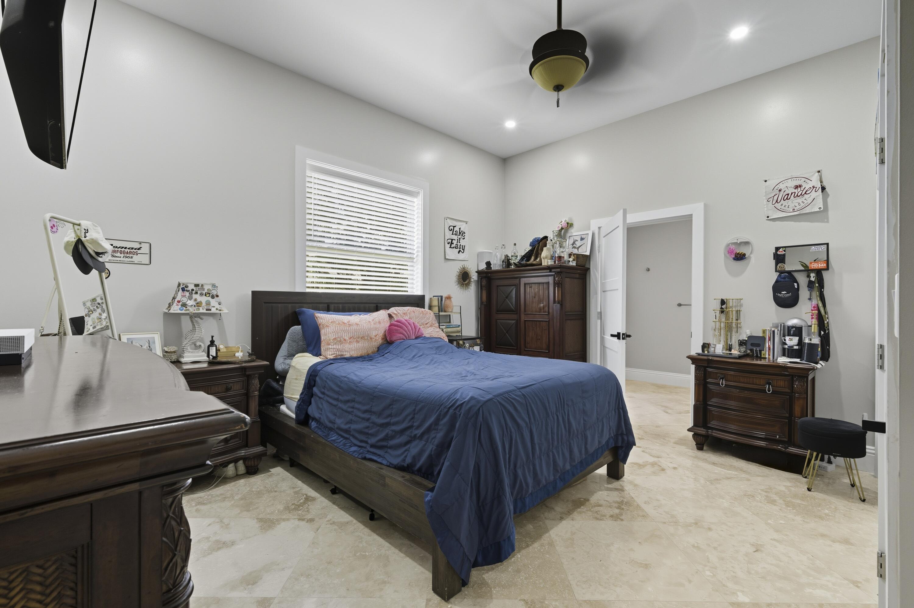 8350 Whispering Oak Way West Palm Beach, FL 33411 - Photo 35 of 51 a bedroom with a bed a dresser and a chandelier