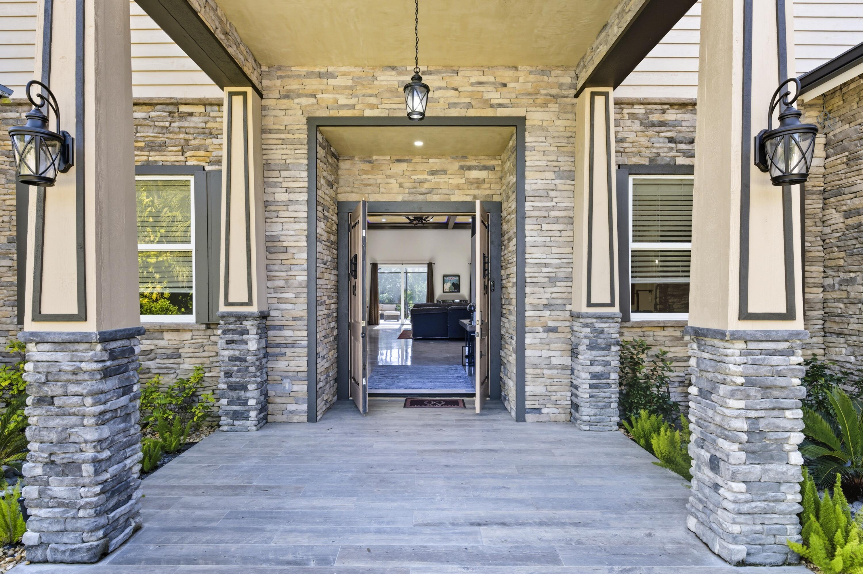 8350 Whispering Oak Way West Palm Beach, FL 33411 - Photo 5 of 51 a front view of a house with a porch