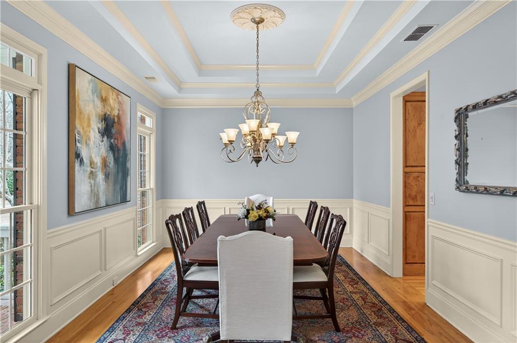 121 Laurel Ridge Drive Alpharetta, GA 30004 - Photo 4 of 14 a dining room with furniture a chandelier and wooden floor