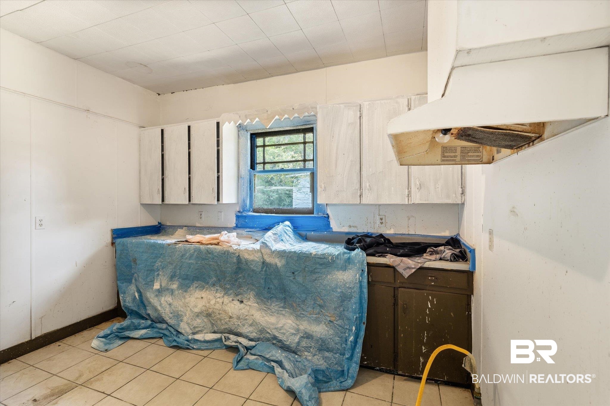 672 Burden Street Mobile, AL 36607 - Photo 6 of 20 Kitchen featuring under cabinet range hood and light tile patterned floors
