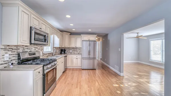a kitchen with a refrigerator a sink and a stove top oven