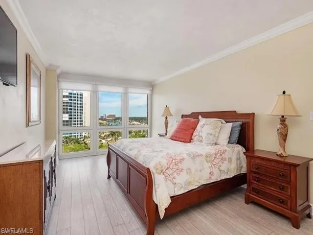 a bedroom with a bed and a dresser next to a window