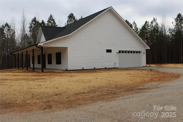 a view of a house with backyard and trees