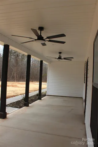 a view of an empty room with a window and a ceiling fan