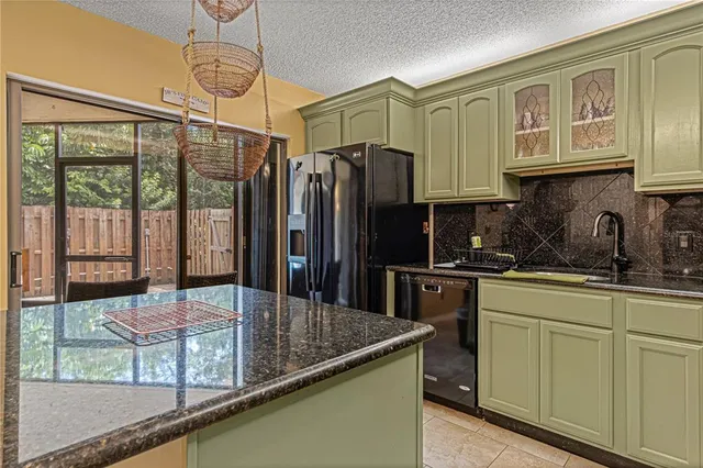 a kitchen with stainless steel appliances granite countertop a refrigerator a stove a sink dishwasher a refrigerator and a dining table with the view