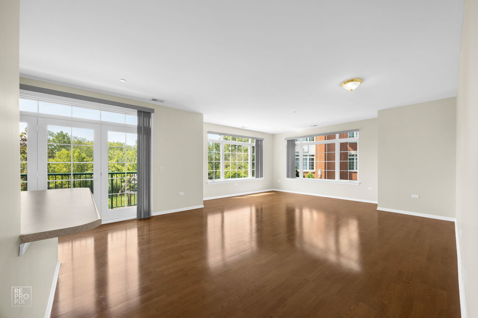 640 McHenry Road, Unit 208 Wheeling, IL 60090 - Photo 3 of 21 a view of an empty room with wooden floor and a window