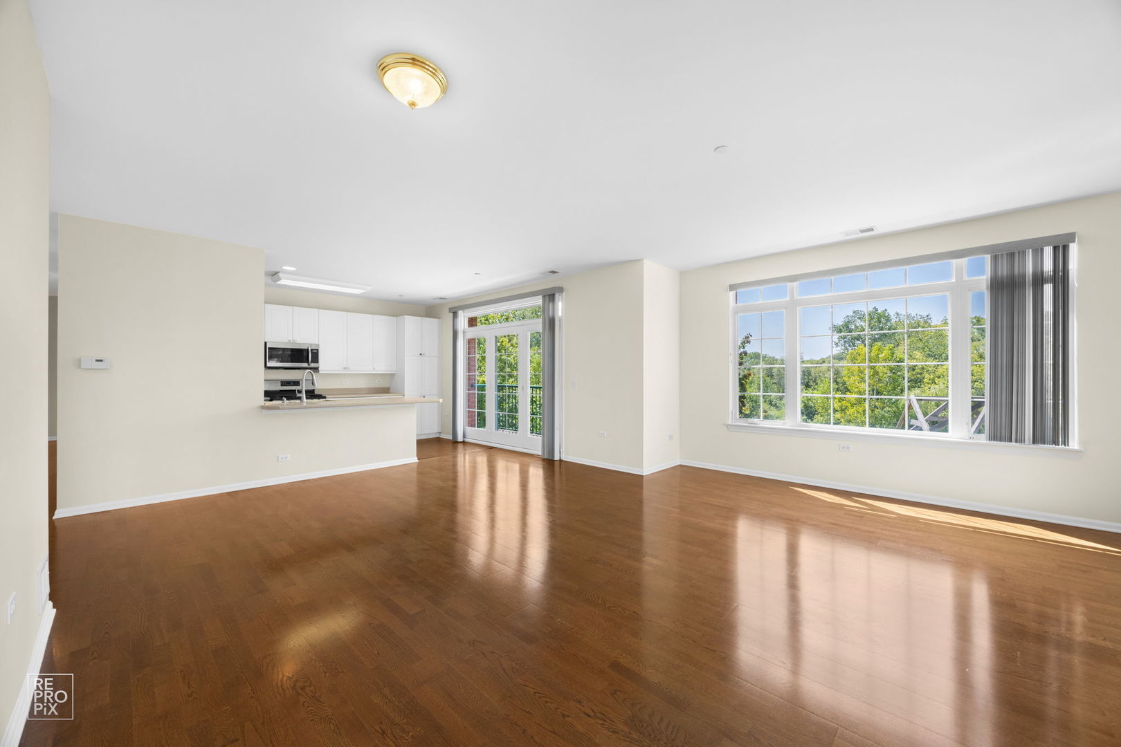 640 McHenry Road, Unit 208 Wheeling, IL 60090 - Photo 4 of 21 a view of an empty room with a window and wooden floor