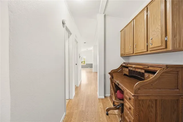a spacious bedroom with a bed a flat screen tv and a chandelier