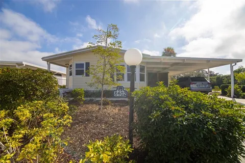 a front view of a house with a yard and potted plants
