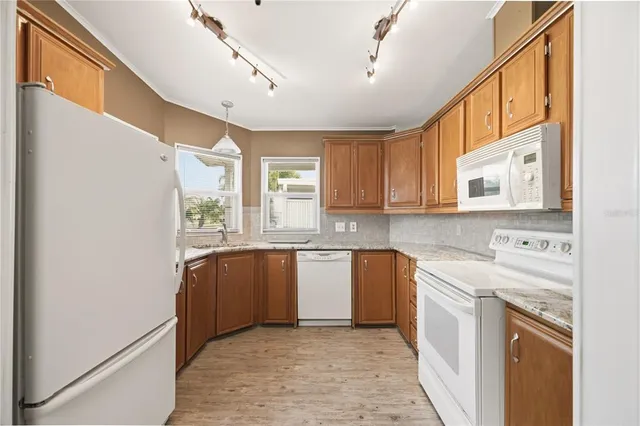 a kitchen with stainless steel appliances granite countertop a refrigerator and a sink