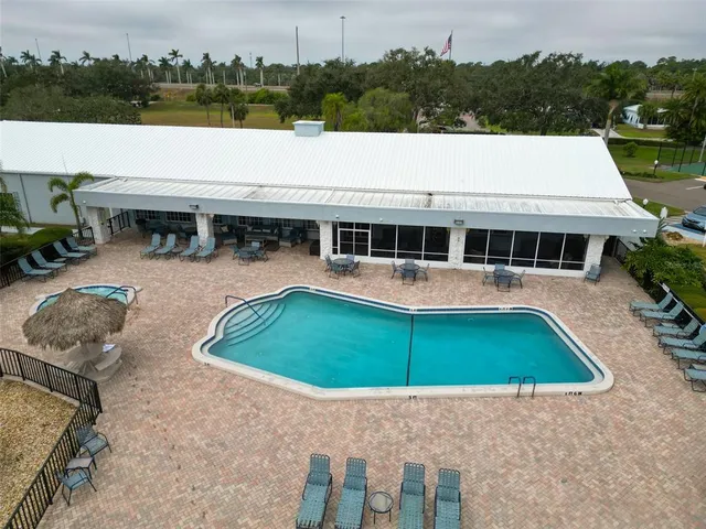 a view of a swimming pool with a patio and a yard