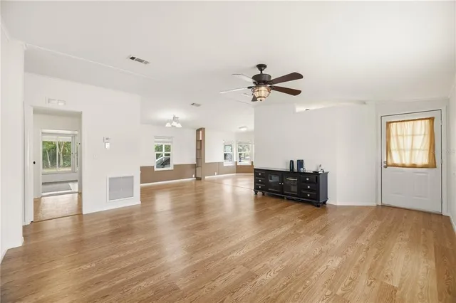 a view of empty room with wooden floor and fireplace