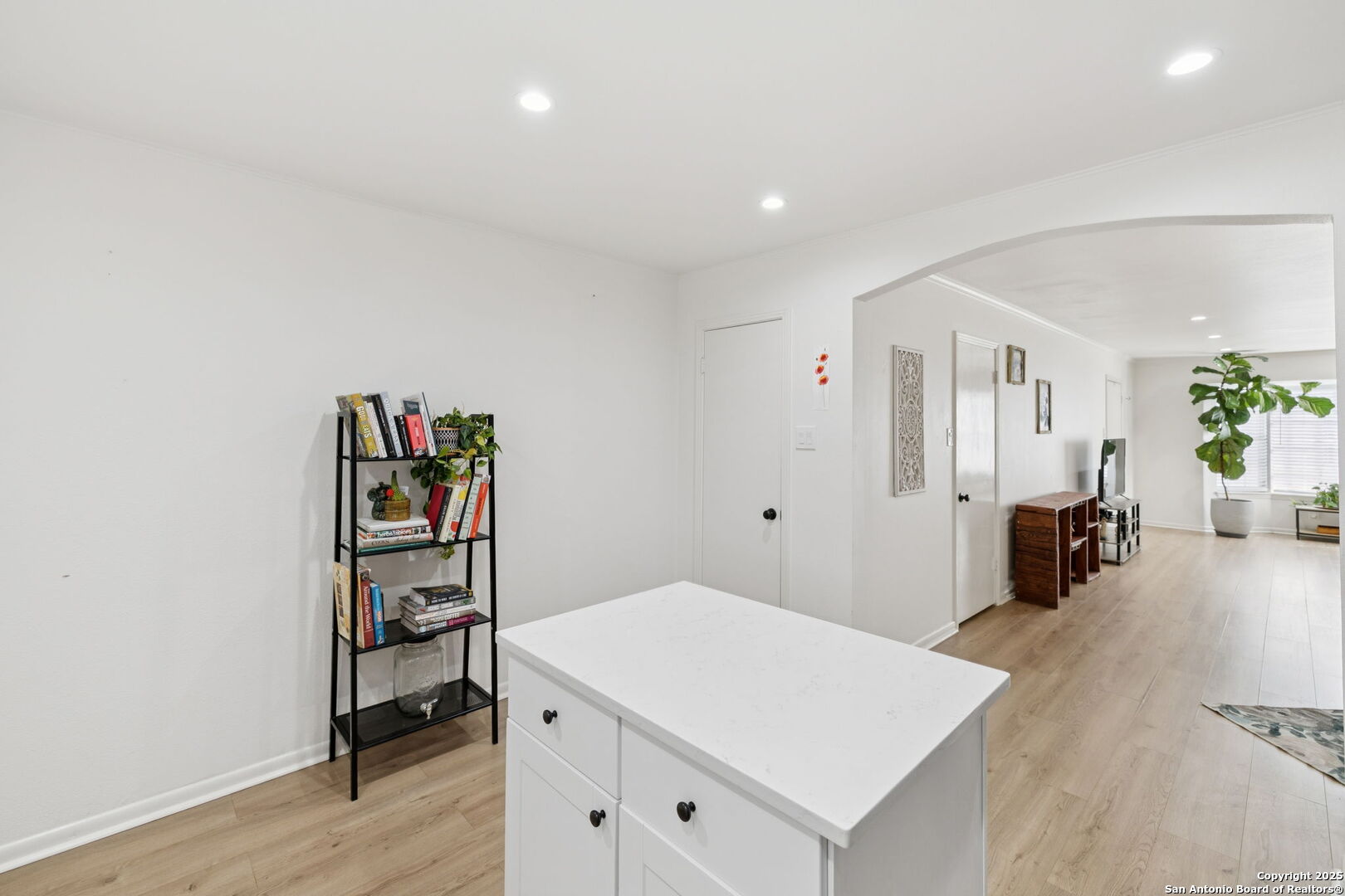 102 Ruelle Lane, Unit 220B San Antonio, TX 78209 - Photo 22 of 37 a hallway with a book shelf and wooden floor