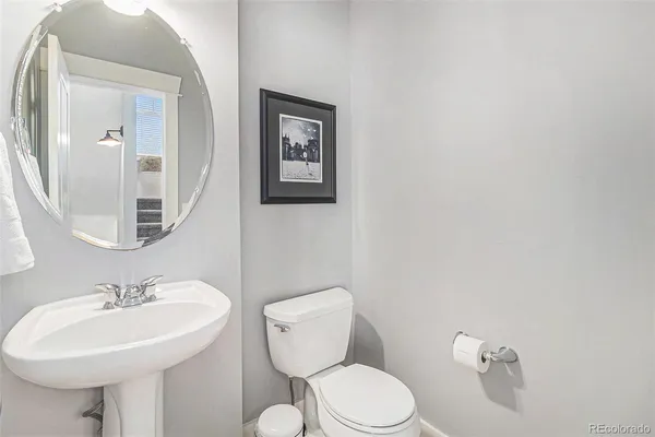 a bathroom with a sink mirror and toilet