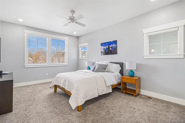a bedroom with a bed and a lamp on dresser