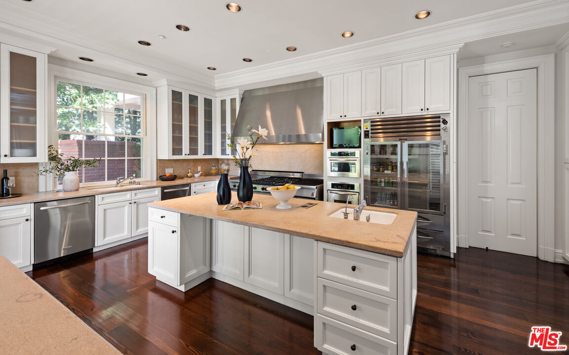 805 North Alpine Drive Beverly Hills, CA 90210 - Photo 18 of 48 a kitchen with a sink stove and wooden cabinets