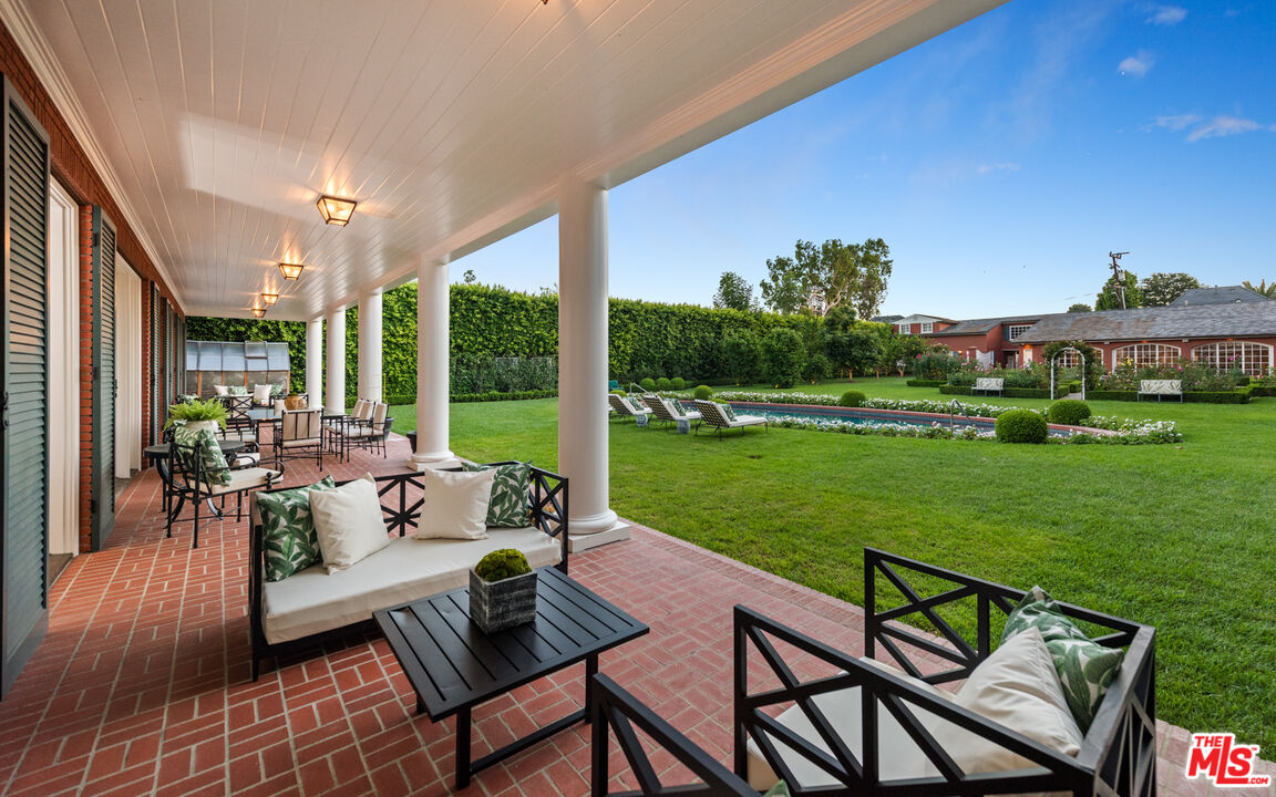 805 North Alpine Drive Beverly Hills, CA 90210 - Photo 20 of 48 a view of a patio with dining table and chairs with garden view