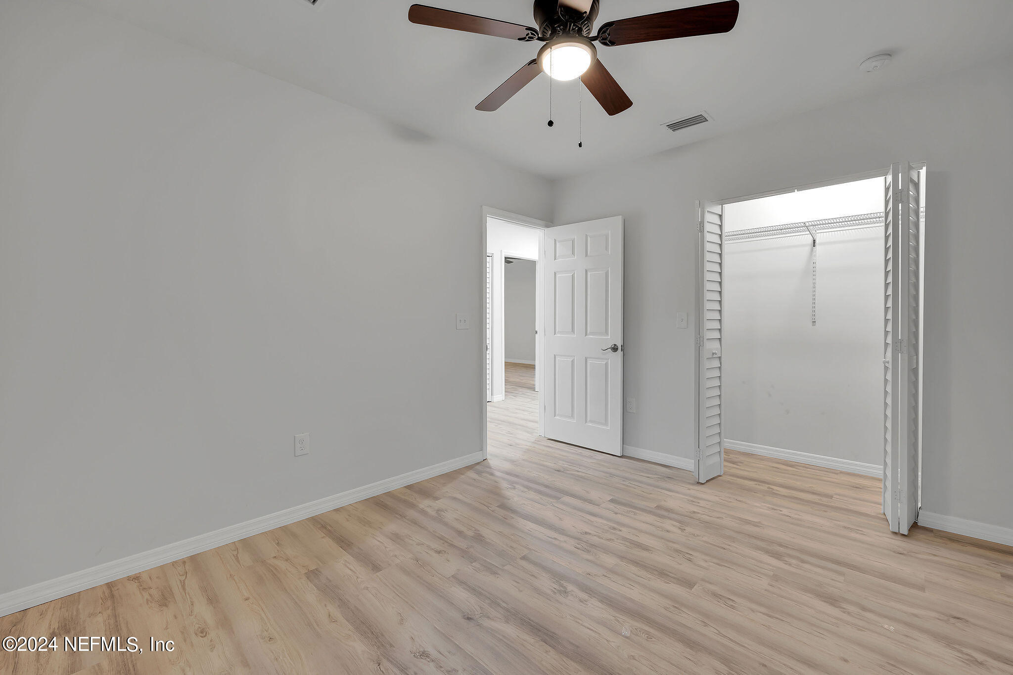 7519 Birdies Road Jacksonville, FL 32256 - Photo 13 of 24 an empty room with wooden floor chandelier fan and windows