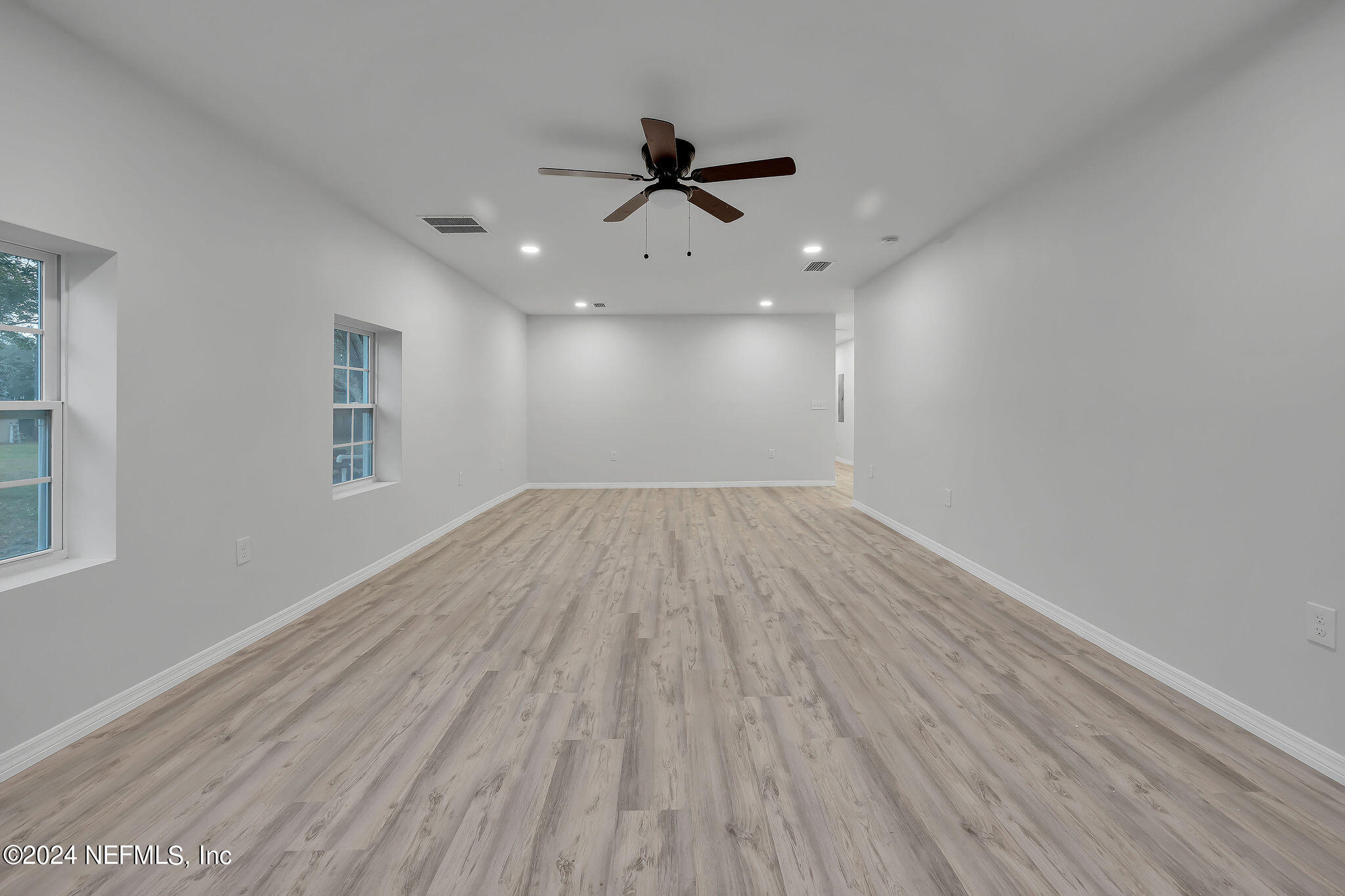 7519 Birdies Road Jacksonville, FL 32256 - Photo 3 of 24 an empty room with wooden floor a ceiling fan and closet