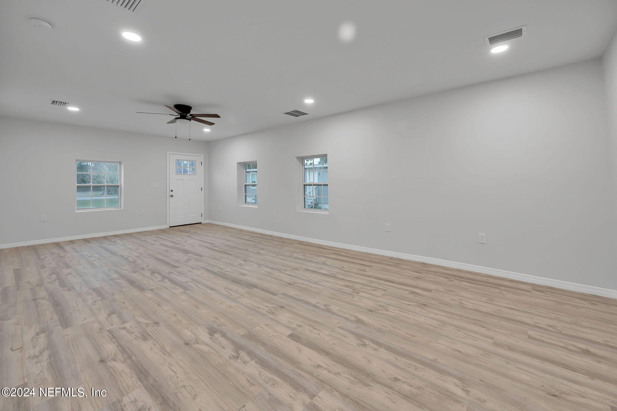 7519 Birdies Road Jacksonville, FL 32256 - Photo 4 of 24 an empty room with wooden floor and windows