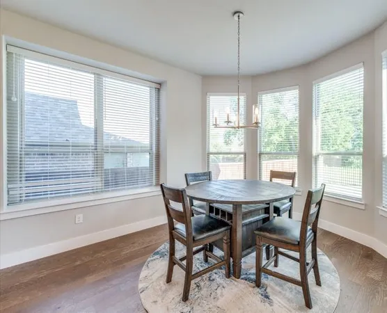 a view of a dining room with furniture large windows and wooden floor