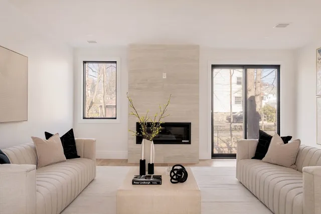 a living room with furniture a flat screen tv and a window