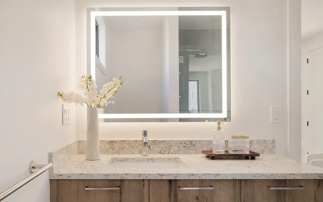 a bathroom with a granite countertop sink and a mirror