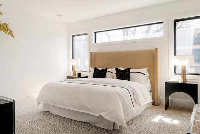 a bedroom with a bed and a large window