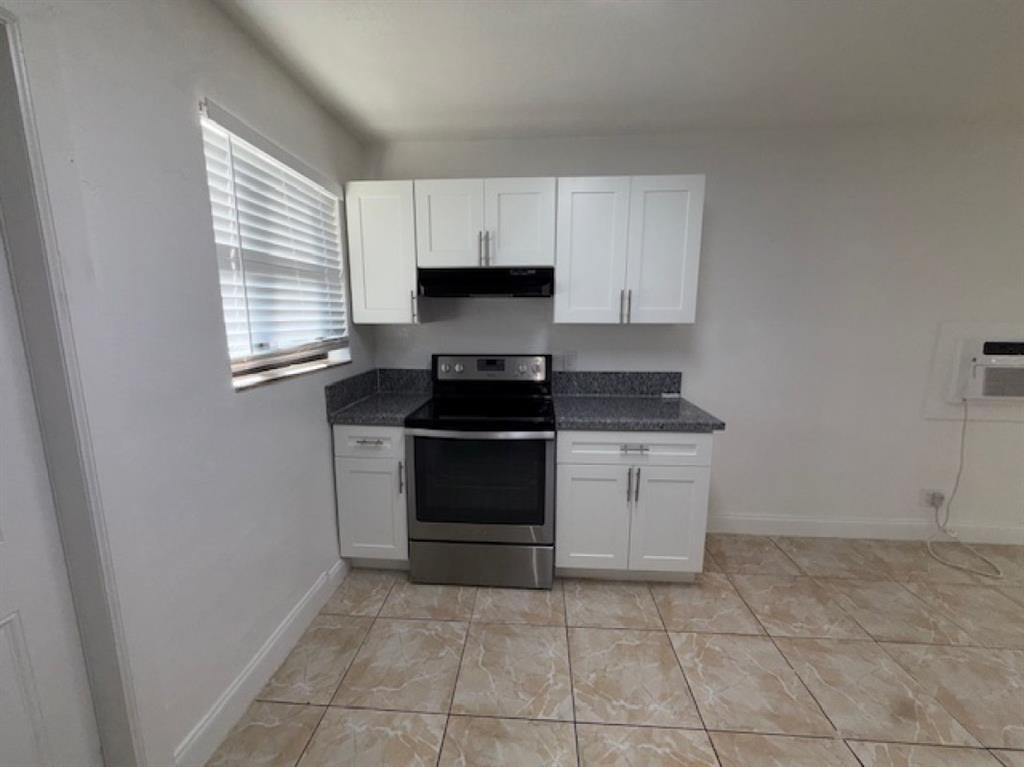 323 Northwest 4th Avenue, Unit R Hallandale Beach, FL 33009 - Photo 2 of 16 a kitchen with a stove top oven and cabinets