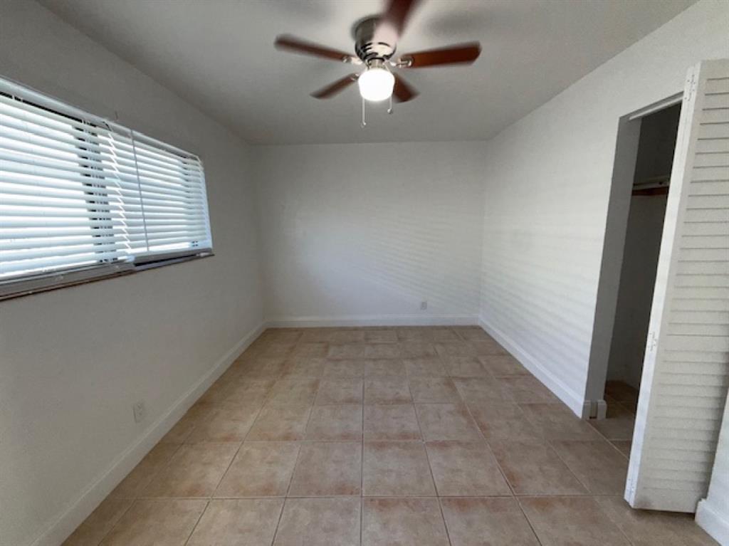 323 Northwest 4th Avenue, Unit R Hallandale Beach, FL 33009 - Photo 9 of 16 an empty room with a window and a fan