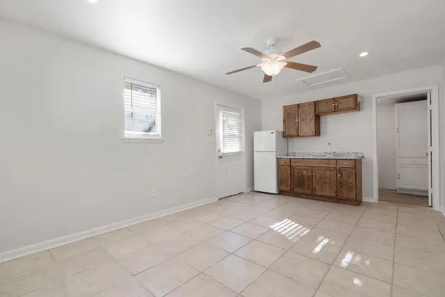 a kitchen with stainless steel appliances a sink a stove a refrigerator cabinets and a window