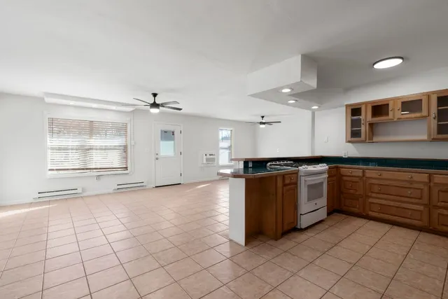 a large white kitchen with a stove top oven and cabinets