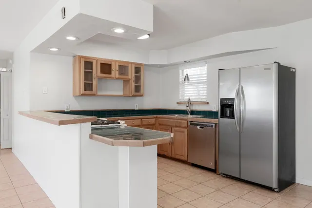 a kitchen with stainless steel appliances granite countertop a sink and a refrigerator