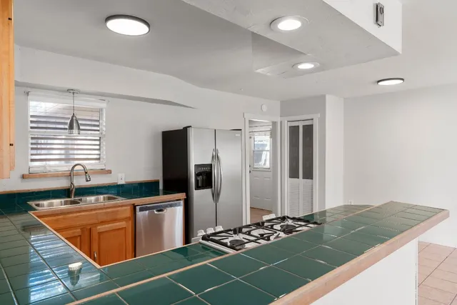 a kitchen with stainless steel appliances granite countertop a sink stove and refrigerator