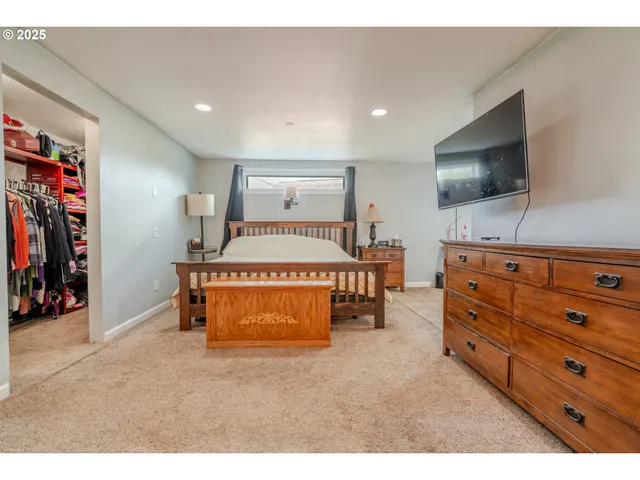 a spacious bedroom with a bed and a flat screen tv
