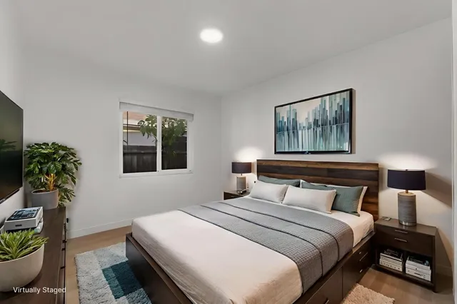 a bedroom with a bed and a potted plant