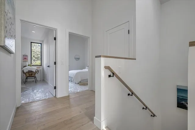 a view of a hallway with bathroom and wooden floor