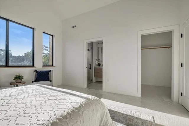 a bedroom with a bed and a painting on the wall