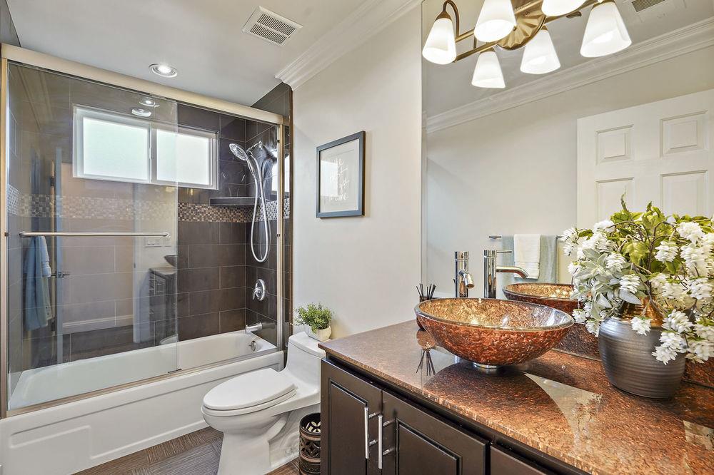 222 Thomas Drive Los Gatos, CA 95032 - Photo 7 of 28 a bathroom with a granite countertop sink a toilet a mirror and shower